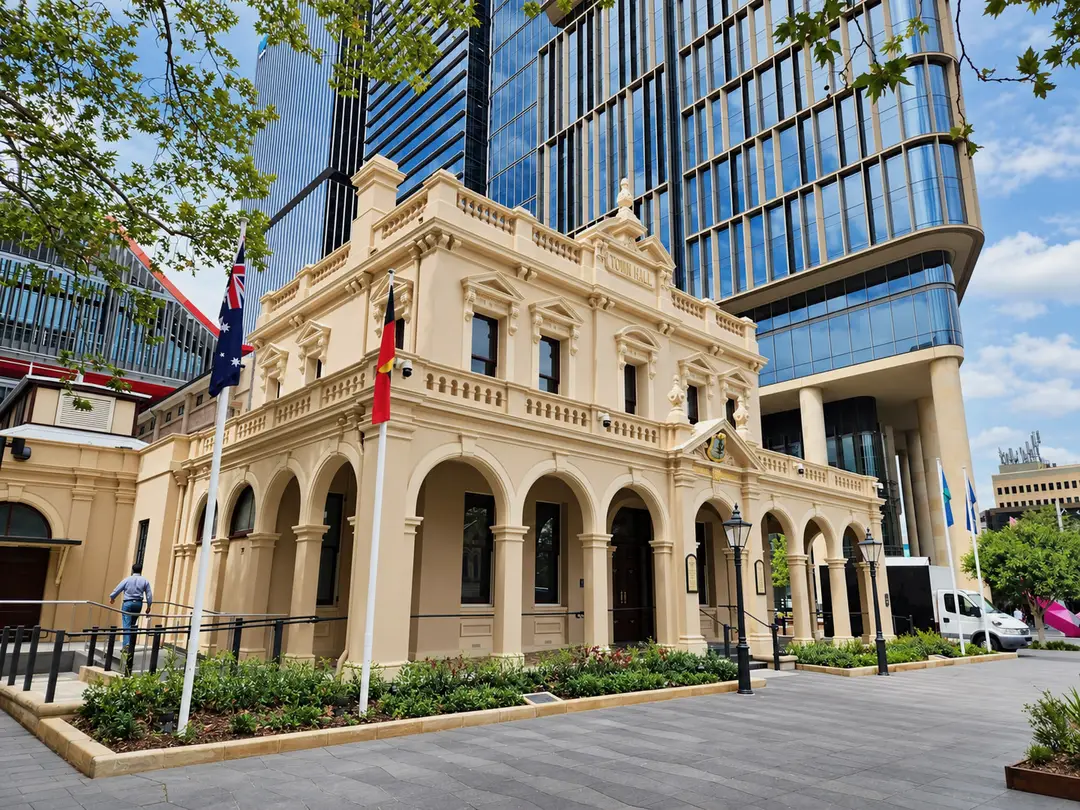 Parramatta Town Hall, a heritage building with flags, in front of modern towers.