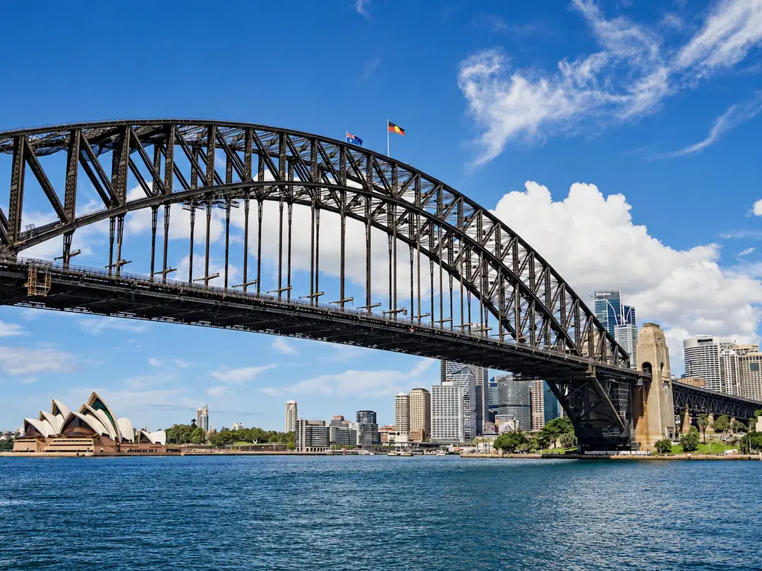 Sydney Harbour Bridge and the Opera House on a clear day, seen across the harbour.
